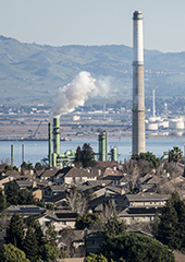 Valero Refinery smokestacks with homes in foreground