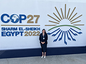 Air District staff member standing in front of COP27 sign at conference in Egypt