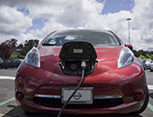 Red electric vehicle charging at station