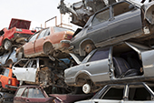 Stacks of demolished vehicles in scrap yard