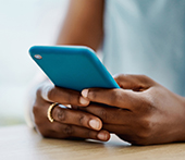 Close up of hands holding blue cell phone