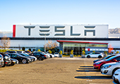 Parking lot with Tesla sign and Tesla cars parked